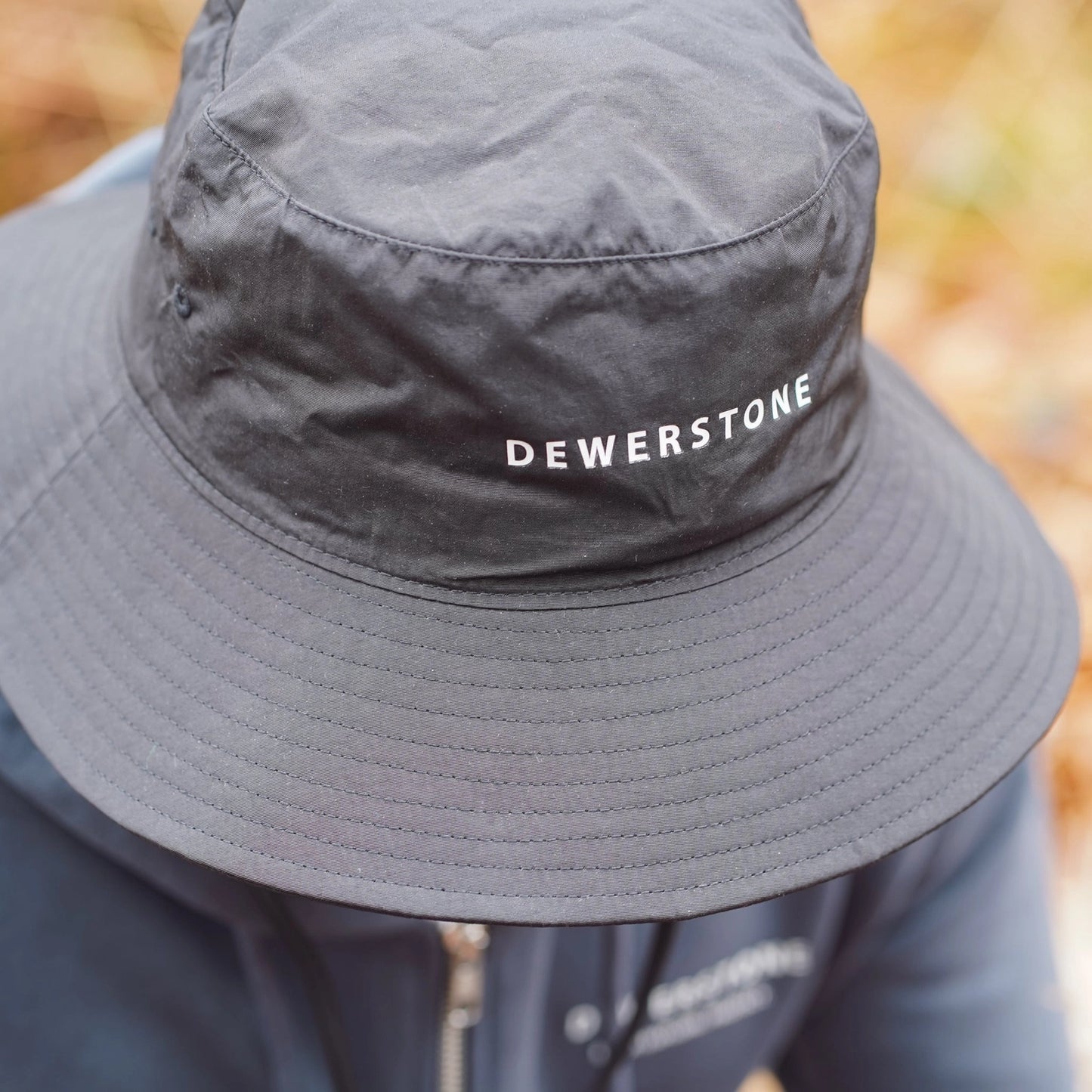 lose-up side view of Dewerstone logo on black recycled bucket hat